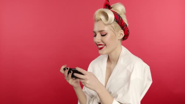 Sonriendo pin up chica usando el teléfono inteligente y mostrando sí gesto — Vídeo de stock