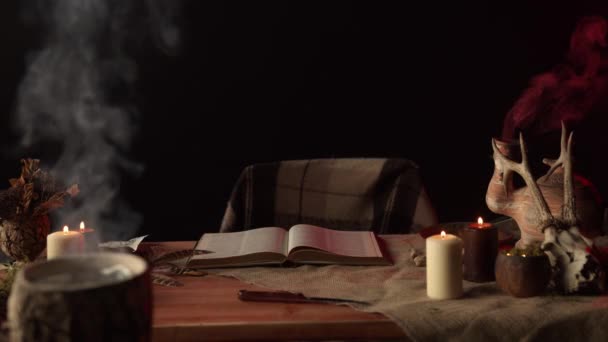 Aufgeschlagenes Buch auf dem Tisch mit magischen Gegenständen — Stockvideo