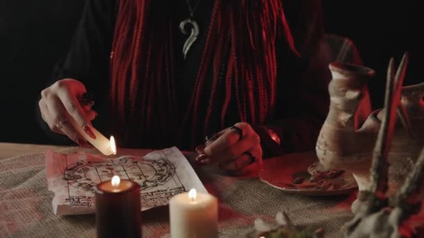 Ausgeschnittene Ansicht einer Hexe mit Zöpfen, die Wachs auf altes Pergament tropft — Stockvideo