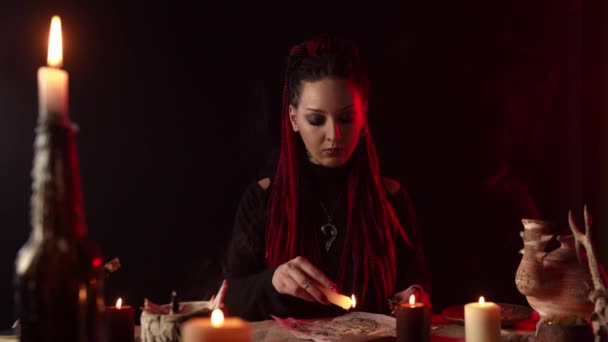 Strega con candele che gocciolano cera sul pentagramma nella stanza buia — Video Stock