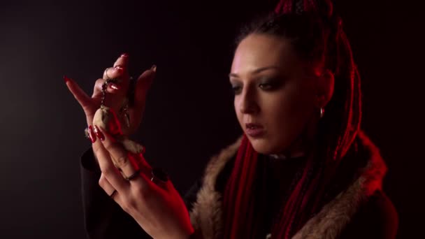 Serious witch with braids holding voodoo doll — 비디오