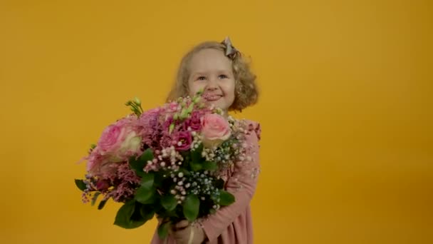 Nadšené dítě drží květiny a ukazuje jazyk s úsměvem — Stock video