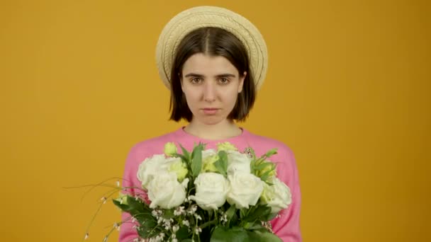 Vista frontal de chica con estilo en sombrero sosteniendo flores con sonrisa — Vídeos de Stock