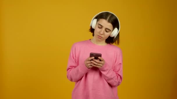 Chica con smartphone escuchando música en auriculares — Vídeos de Stock
