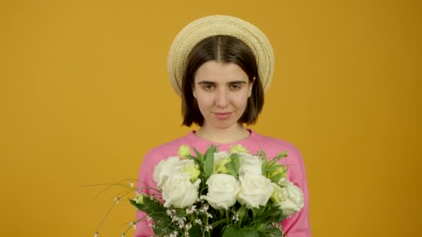 Chica de moda en sombrero sosteniendo flores con suavidad sonrisa — Vídeos de Stock