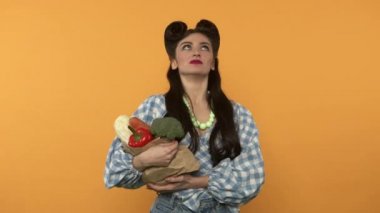 Ekolojik çantasında vejetaryen yiyeceği olan kız kameraya bakıyor.