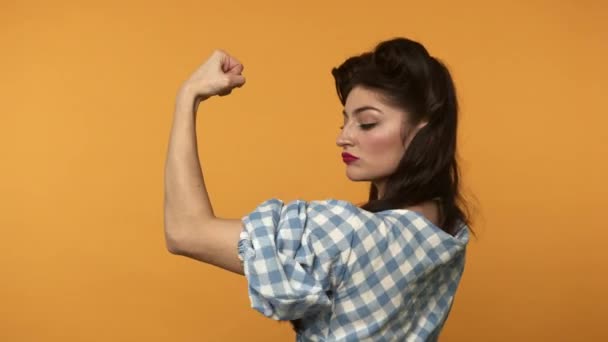 Confiado pin up mujer mostrando bíceps y guiño con sonrisa — Vídeo de stock