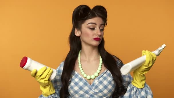 Pin up girl in rubber gloves looking at cleaning supplies — Stock Video