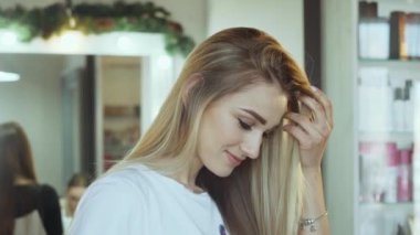 Güzellik salonunda kameraya gülümseyen güzel bir kadının portresi.