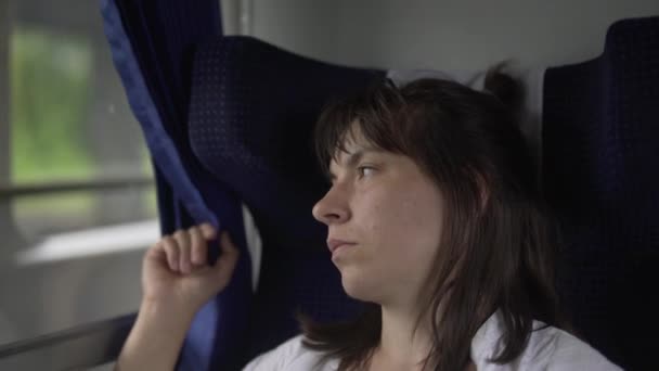 一个忧郁的女人带着忧郁的目光坐在火车上。例程 — 图库视频影像