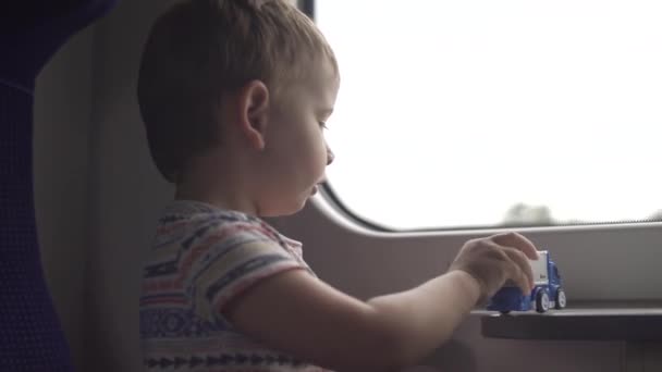 Petit garçon jouer avec des jouets tout en voyageant dans le train et se sentir ennuyeux — Video