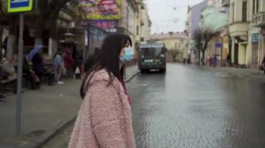 Bir kadın karşıdan karşıya geçiyor ve yakınlarda biri var mı diye kontrol ediyor. Virüs salgını, salgın hastalık. covid 19