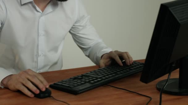 Oficina, cerca de manos masculinas, teclado y ratón de la computadora, un hombre trabaja en una computadora — Vídeo de stock