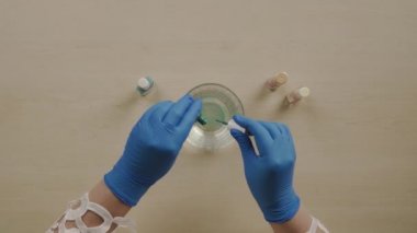 Paskalya yumurtası boyayan kadın. Sanat eserleri için suya farklı oje sürerler.