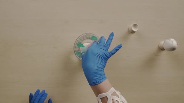 Mujer pintando huevos de Pascua. Pone un huevo en el agua, para pintar arte — Vídeos de Stock