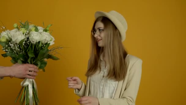 Menina atraente em óculos aceitando flores e posando com sorriso — Vídeo de Stock