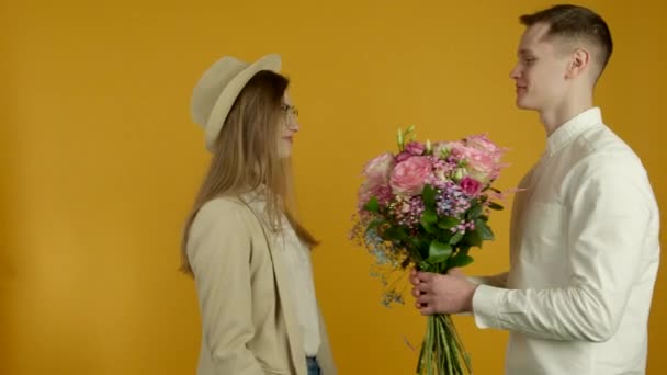 Mladý muž představuje květiny na přítelkyni — Stock video