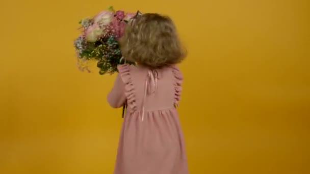 Spännande unge med blommor, hoppa och dansa med leende — Stockvideo