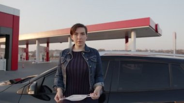 Genç kadın tıbbi maske takıyor. İçinde çocuklar olan bir arabanın yanında kal. Çıldırdı. Coronavirüs