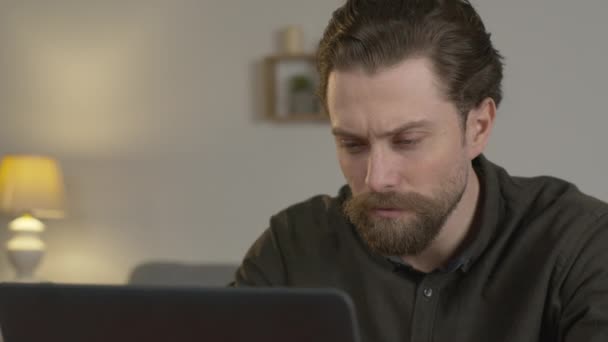 un homme travaille sur un ordinateur portable, imprime, s'assoit à une table, travaille de la maison.