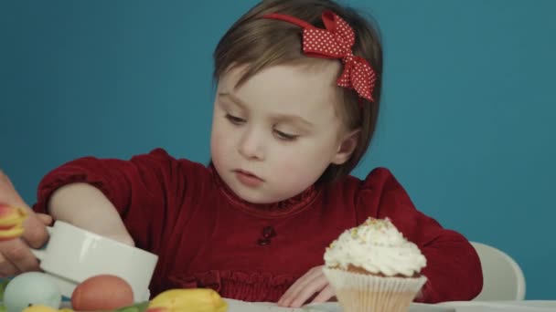 Dívka připravuje dort na Velikonoce. posypané barevnými sladkostmi. Veselé Velikonoce — Stock video