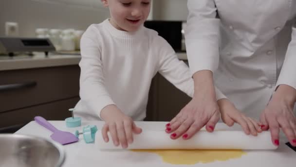 Mãe ensina filho a cozinhar biscoitos de biscoito, eles fazem massa juntos, menino aprende — Vídeo de Stock