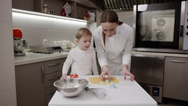Mor och son kock i köket, vit tunika, ljust kök, pojke leenden — Stockvideo