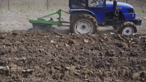 Ciągnik uprawia ziemię do sadzenia ziemi. sadzenie warzyw przeznaczonych do żywienia domowego — Wideo stockowe