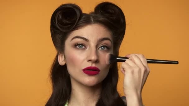 Красива жінка прикладає макіяж фундамент на обличчі — стокове відео