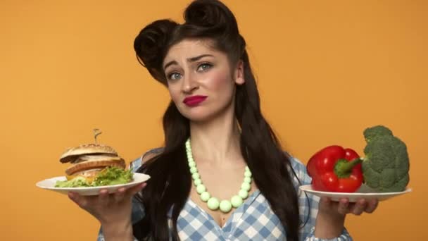 Pin up kvinna som håller burgare med grönsaker och skakande huvud — Stockvideo