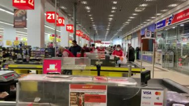 Chernivtsi, Ukrayna - 20 Nisan 2020: Covid-19 Coronavirus salgını sırasında insanlar süpermarketin kasasında ürünlere para ödüyor. İnsanlar karantina ve izolasyon süresince yiyecek satın alırlar.