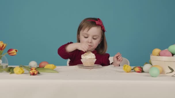 Mädchen bereitet eine Torte für Ostern vor. bestreut mit bunten Süßigkeiten. Frohe Ostern — Stockvideo
