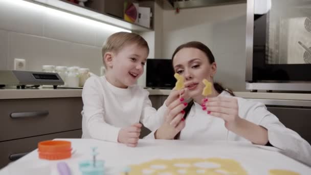 Bambino felice con la sua madre felice preparare i biscotti di Pasqua insieme, prepararsi per la vacanza, emozioni positive — Video Stock