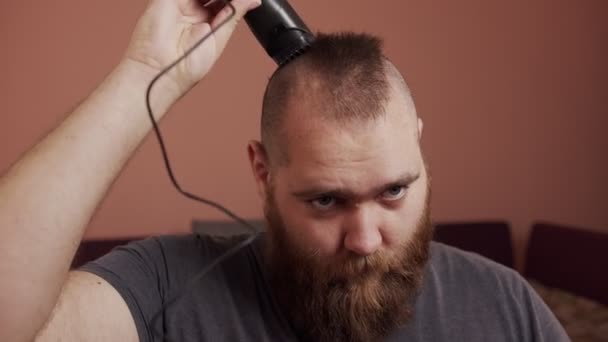 Corte de cabelo e barba em casa por epidemia de infecção pelo coronavírus COVID-19. Homem faz um corte de cabelo em casa, porque todas as barbearias estão fechadas — Vídeo de Stock