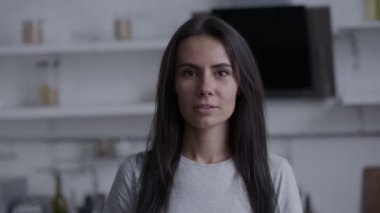 Gözlerinde acıma duygusu olan ifade edici bir yüzü olan esmer, kameraya bakar ve başını sallar. Üzgünüm üzücü hikaye.