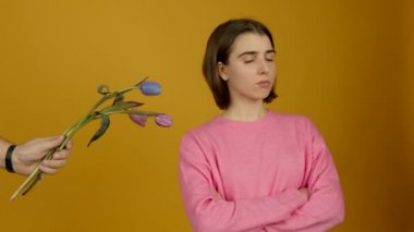 Kolları çapraz duran ve çiçekleri koparan bir kız gücendi