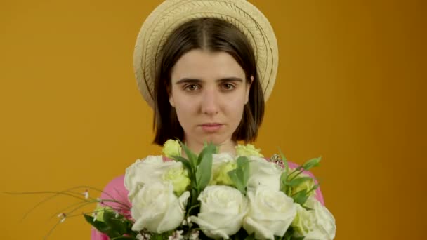 笑顔で花を保持帽子の魅力的な女の子のフロントビュー — ストック動画