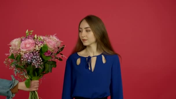 Alegre chica atractiva aceptando flores y sonriendo a la cámara — Vídeos de Stock