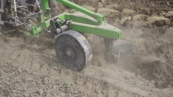 Крупным планом трактор обрабатывает землю для посадки земли. посадка овощей для питания — стоковое видео