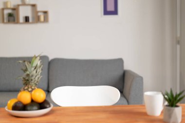 Genç bir adam masaya oturur ve meyvelerin faydasından bahseder, meyveleri toplar ve ananas, avokado, portakal gösterir. Sağlıklı yemek.