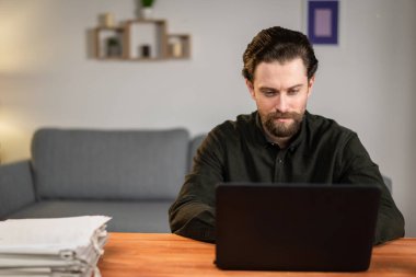 Bir adam dizüstü bilgisayarda çalışıyor, parmak izi alıyor, masaya oturuyor, evden çalışıyor. Evde kalıp meydan okuyorum.