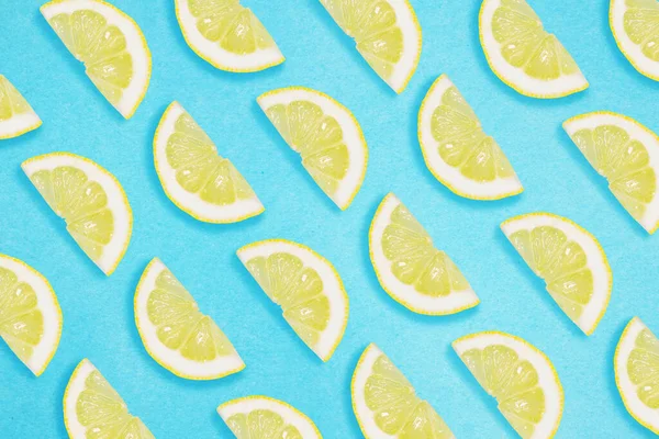 Border of lemon slices on a blue background. Flat lay summer concept.