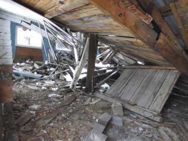 Terk edilmiş bir binanın yıkılması. Harap olmuş ahşap ev. Binanın yıkıntıları. Evin çökmüş çatısı. İç görünüm.