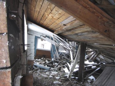 Harap olmuş ahşap bina. Ahşap bir evin çökmüş çatısı. Terk edilmiş bina. Harap olmuş eski bir yapı var. Terk edilmiş eski fabrika..