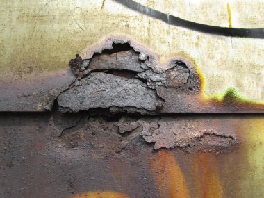 Paslı doku. Grunge metal arka planı. Eski terk edilmiş bir demir garajın yüzeyinde aşınma ve pas var. Yakın plan..