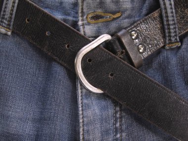 Kotun üzerindeki eski deri kemer. Klasik kahverengi pantolon kemeri. Kot pantolon arka planı. Erkekler tuvaleti. Denim dokusu.
