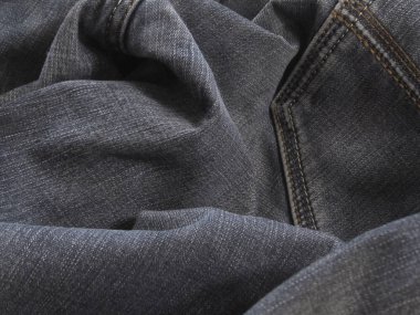 Siyah kot kumaşı. Koyu gri kotlar. Denim yığını. Buruşuk eski kotlar.