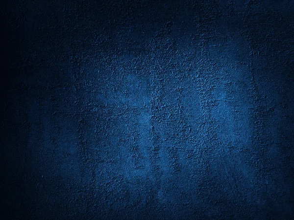 Dark blue grunge background. Rough grainy concrete wall surface texture. Close-up. Abstract blue background. Dark blue concrete background. Detail. Copy space for your design.