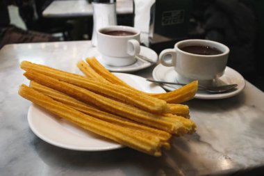 Churros and hot chocolate at Chocolateria San Gines in Madrid, Spain. clipart