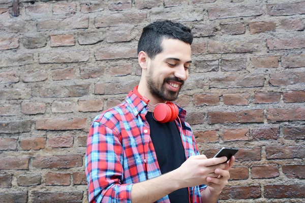 Latin ember gépelés a telefonját. — Stock Fotó